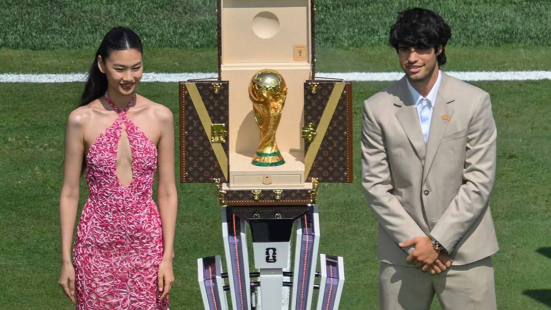 Actress Jung Ho-yeon and Carlos Alcaraz present the FIFA World Cup trophy before the final Sunday between Argentina and Spain.